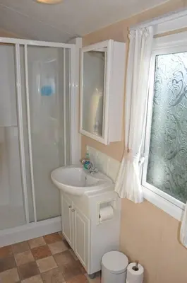 a white bathroom with a sink and a shower at Happy Days Holiday Home Whithorn2 in Newton Stewart