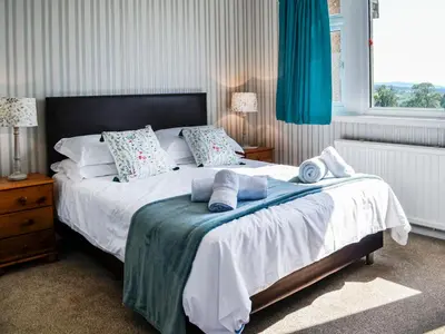 a bedroom with a bed with towels on it at Woodend Farmhouse Halmyre in Haugh of Urr