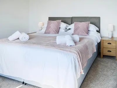 a bedroom with a large bed with towels on it at Woodend Farmhouse Halmyre in Haugh of Urr