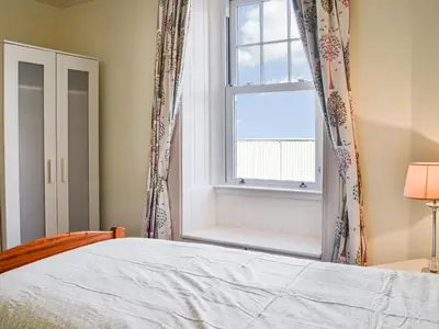 a bedroom with a bed and a window at Repentance View in Carrutherstown
