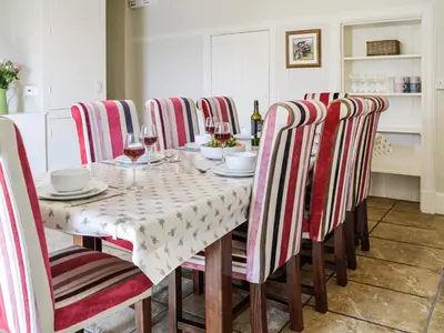 a dining room with a table and chairs with wine glasses at Repentance View in Carrutherstown