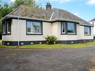 a white house with black windows on a street at Stronvaar in Stranraer