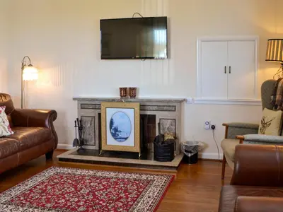 a living room with a fireplace with a flat screen tv at Kinvara in Stranraer