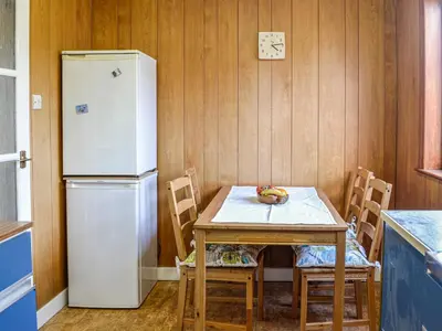 a small kitchen with a table and a refrigerator at Ardencaple No 2 in Castle Douglas