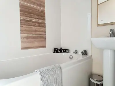 a white bathroom with a tub and a sink at Graylings Rest - Uk35759 in Brigham