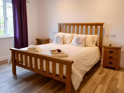 a bedroom with a large bed with towels on it at Inverallan in Amisfield Town