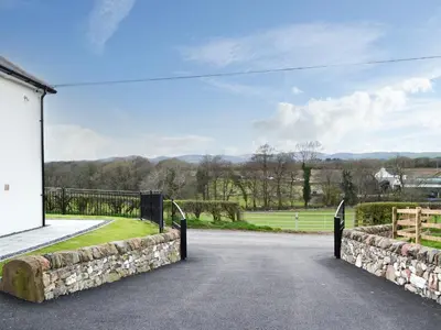 a driveway with a fence and a tennis court at Inverallan in Amisfield Town