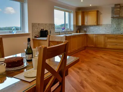 a kitchen with a table with a cake on it at Inverallan in Amisfield Town