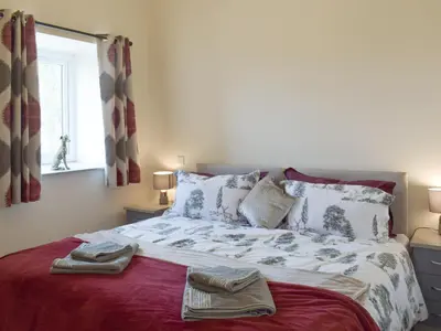 a bedroom with a bed with two towels on it at Uk7385 - Chaff House in Newmilns
