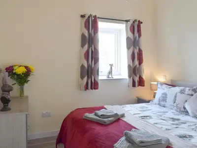 a bedroom with a bed with two towels on it at Uk7385 - Chaff House in Newmilns