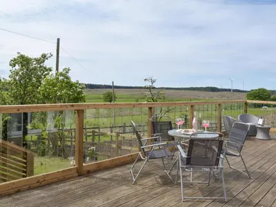 a wooden deck with a table and chairs on it at Uk7385 - Chaff House in Newmilns