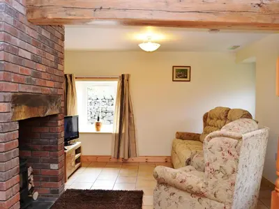 a living room with a couch and a fireplace at Shepherds Cottage in Corney