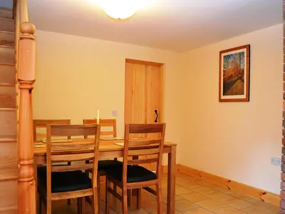 a dining room with a wooden table and chairs at Shepherds Cottage in Corney