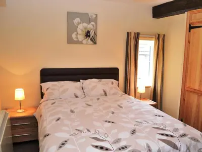 a bedroom with a bed with a flower on it at Shepherds Cottage in Corney