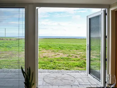a sliding glass door with a view of a field at The Seaview Snug in Whithorn