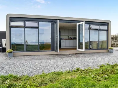 a modern house with large windows and a patio at The Seaview Snug in Whithorn