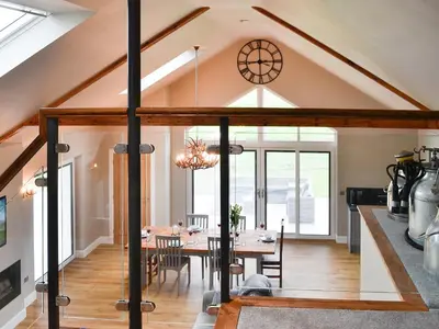 an attic dining room with a table and chairs at The Byre in Castle Douglas
