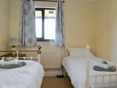 two twin beds in a room with a window at High Mains in Winscales