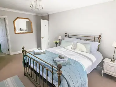 a bedroom with a large bed and a mirror at High Mains in Winscales