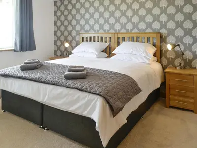 a bedroom with a large bed with towels on it at Gin Case in Templand