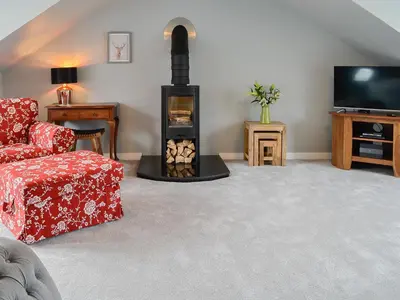 a living room with a fireplace and a tv at The Old Toll House in Portpatrick