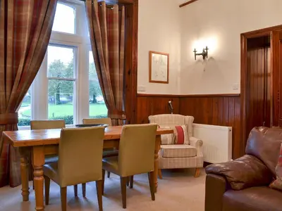 a living room with a wooden table and chairs at Lealholme in Bassenthwaite