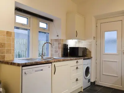 a kitchen with a sink and a washing machine at Lealholme in Bassenthwaite