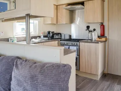 a kitchen with wooden cabinets and a stove top oven at Loch View in Kirkcolm