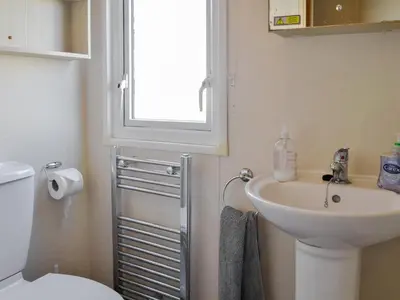 a bathroom with a sink and a toilet and a window at Loch View in Kirkcolm