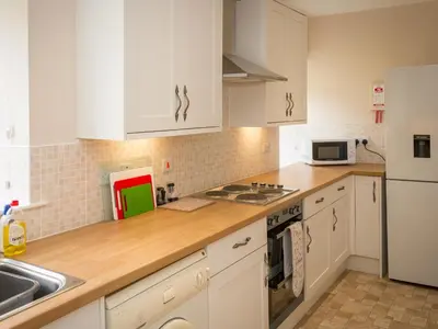 a kitchen with white cabinets and white appliances at Uk35716 - North Cottage in Teviothead