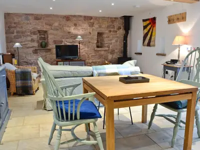 a living room with a table and chairs and a couch at The Barn in Greystoke