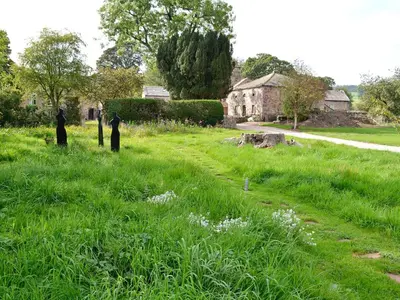 two people standing in the grass in a field at The Barn in Greystoke