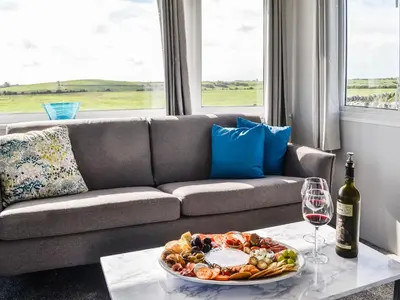 a table with a plate of food and a wine glass at The Seaview Retreat - Uk35883 in Broughton Mains