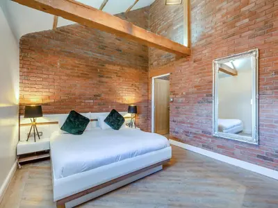 a bedroom with a bed and a brick wall at The Barnacle Goose - Uk35261 in Bowness-on-Solway