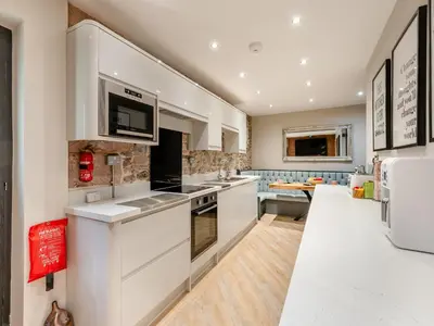 a kitchen with white cabinets and a counter top at The Barnacle Goose - Uk35261 in Bowness-on-Solway
