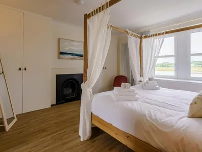a bedroom with a canopy bed with a fireplace at Erriff At Caelaverock in Glencaple