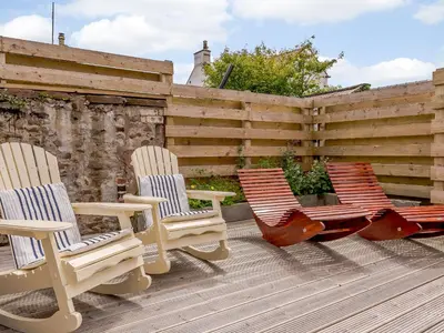 two chairs and a hammock sitting on a deck at Erriff At Caelaverock in Glencaple