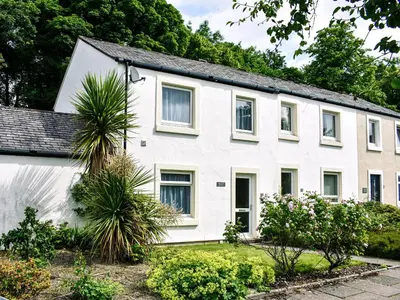 a white house with plants in front of it at Jane Eyre Cottage in Keswick