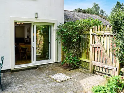 a garden entrance to a house with a wooden fence at Jane Eyre Cottage in Keswick
