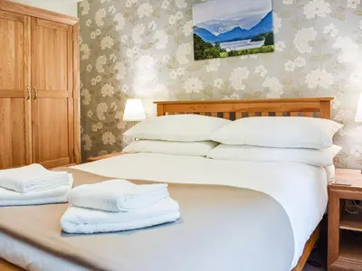 a bedroom with a bed with towels on it at Jane Eyre Cottage in Keswick