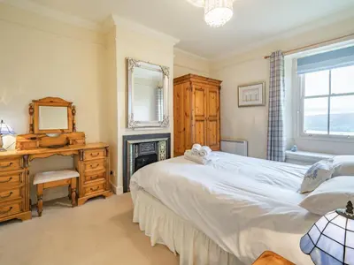 a bedroom with a bed and a desk and a mirror at Mell Fell in Watermillock