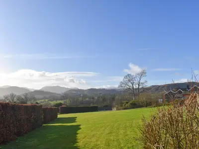 a grassy field with mountains in the background at Mell Fell in Watermillock