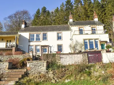 a white house on a hill with a fence at Mell Fell in Watermillock