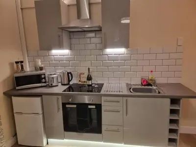 a kitchen with a counter with a sink and a microwave at Carlisle City Centre, Cute Victorian House. in Carlisle