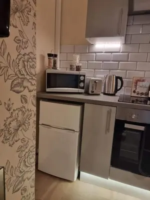 a kitchen with a counter with a microwave and a refrigerator at Carlisle City Centre, Cute Victorian House. in Carlisle