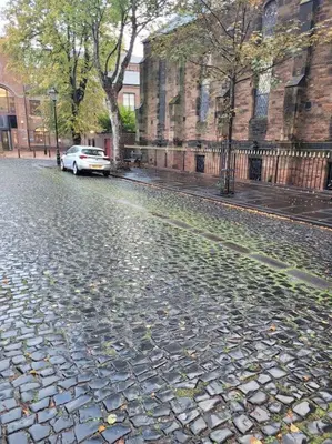 a white car parked on a cobblestone street at Carlisle City Centre, Cute Victorian House. in Carlisle