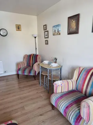a living room with two couches and a table at West View Cottage in Seaside Village of Allonby Cumbria in Allonby
