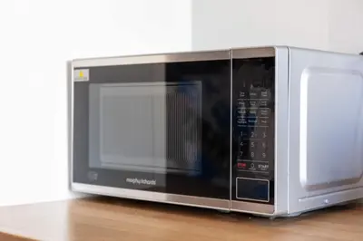 a microwave oven sitting on top of a wooden table at The Orchard - Donnini Apartments in Ayr
