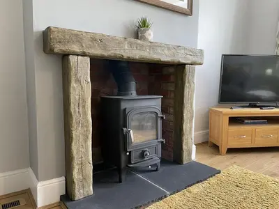 a fireplace with a stove in a living room at Glenderamackin Cottage in Threlkeld