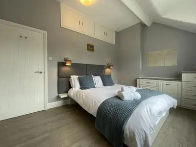 a bedroom with a bed with two towels on it at Glenderamackin Cottage in Threlkeld